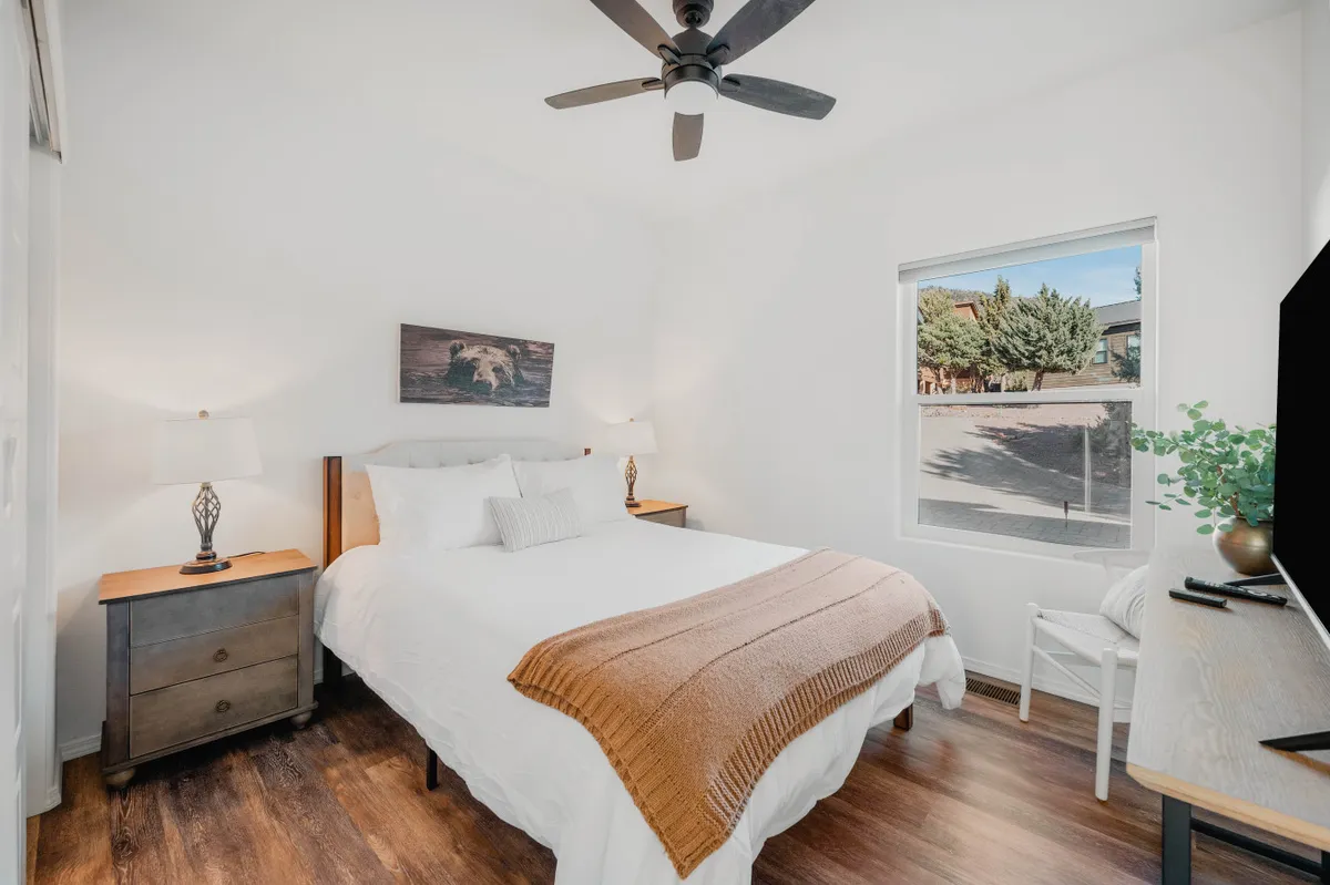 A tranquil bedroom with a comfortable bed, nightstands on either side, a window allowing in soft natural light, and tasteful artwork on the wall. The ambiance is peaceful, inviting relaxation and restful sleep.